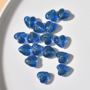 Close-up of royal blue heart-shaped glass beads with gold glitter for DIY jewelry making