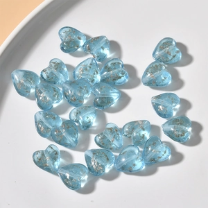 Macro view of sky blue heart glass beads with gold foil inclusions for DIY jewelry