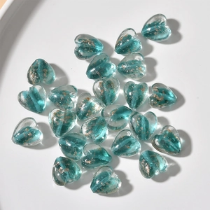 Macro shot of heart-shaped glass beads with gold foil inside for DIY jewelry making
