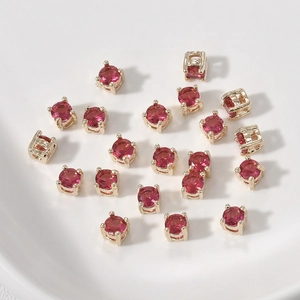 Vista macro de mini cuentas de circón rojo con engaste chapado en oro para joyería artesanal