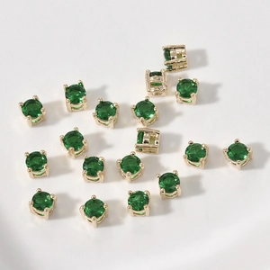 Detalle macro de cuentas espaciadoras de circonita verde bañada en oro para joyería