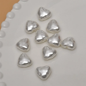 Close-up of heart-shaped faux pearl beads with metallic luster for DIY jewelry making