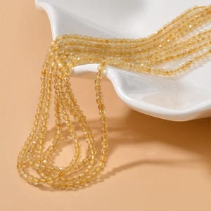 Vue macro de perles en pierre naturelle jaune ambre facettées de 2-3 mm sur un plateau