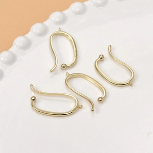 14k gold plated U-shaped ear clip hooks for DIY jewelry making displayed on a white plate