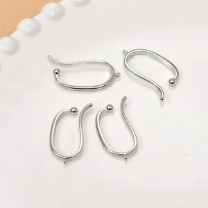Close-up of polished silver U-shaped DIY jewelry earring hooks on a ceramic plate