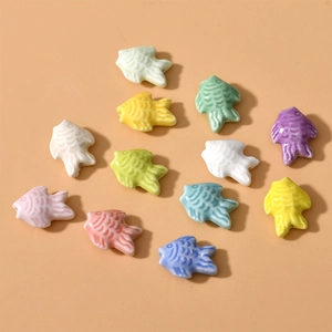 Macro detail of colorful fish-shaped ceramic beads with scales for DIY jewelry making