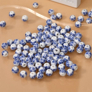 Blue and white floral ceramic beads for DIY jewelry making displayed on a modern tray