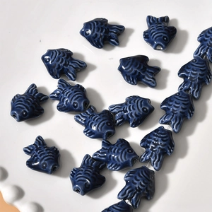 Macro detail of dark blue ceramic fish beads with fine texture for DIY jewelry making