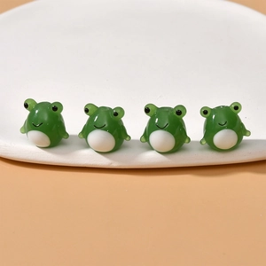 Macro detail of cute green frog glass beads for DIY jewelry making and handmade crafts