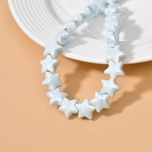 Light blue ceramic star beads for DIY jewelry making on a minimalist tray