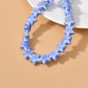 Close-up of blue star-shaped ceramic beads with marble texture for DIY jewelry making