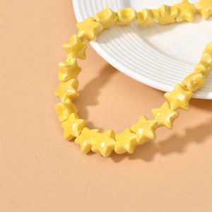 Macro shot of glossy bright yellow star-shaped ceramic beads for DIY jewelry making