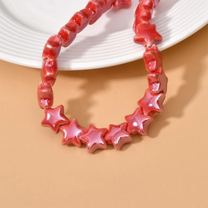 Close-up of glossy red star-shaped ceramic beads for DIY jewelry making and crafts