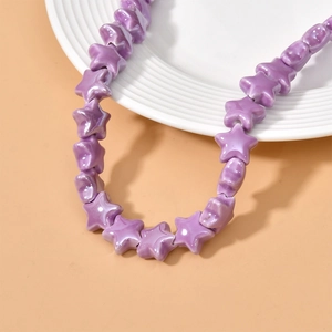 Detailed view of glossy purple star-shaped ceramic beads for DIY handmade jewelry crafts