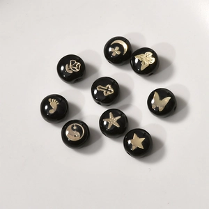 Amuletos redondos en negro y oro con estrellas y mariposas para joyería artesanal