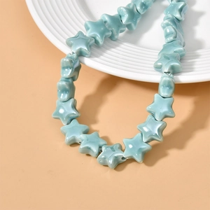 Close-up of sky blue star-shaped ceramic beads with a glossy glazed finish for DIY jewelry