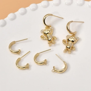14k gold plated C-shape astronaut bear earrings with sparkling crystals in ceramic tray