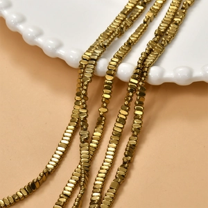 Polished 2x4mm gold plated hematite block beads for DIY jewelry making on white ceramic