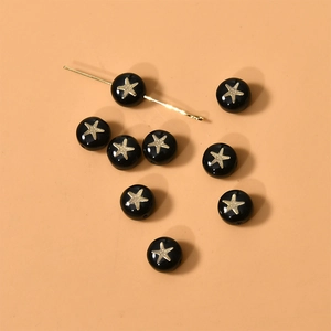 Vista macro de cuentas redondas negras con patrón de estrella de mar dorada para joyas