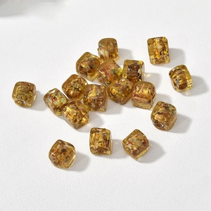 Close-up of amber cube beads with gold foil inside for DIY handmade jewelry crafting