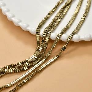 Macro shot of 2x4mm gold plated hematite faceted rectangular beads for DIY jewelry