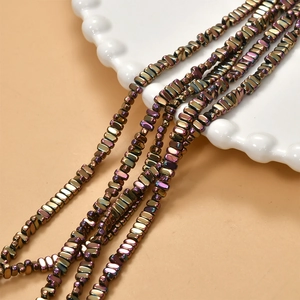 Macro detail of 2x4mm rectangular hematite beads with iridescent metallic plated finish