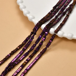 Macro detail of iridescent purple hematite beads with metallic luster on white porcelain