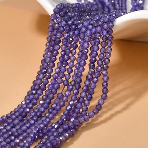 Detailed macro view of 2mm faceted deep purple zircon loose beads for DIY jewelry making