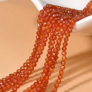 Macro shot of 2mm faceted orange zircon beads for DIY jewelry making and necklaces