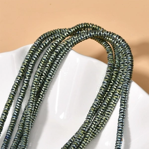Macro shot of 4x1mm wave-shaped hematite spacer beads with iridescent metallic luster