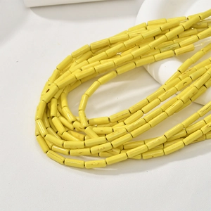 Close-up of vibrant yellow turquoise tube beads with natural texture on a white background