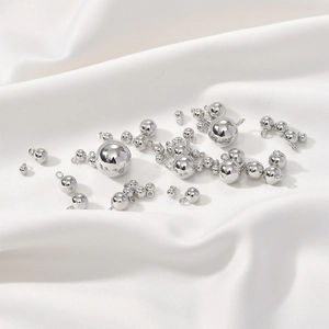 Pendentifs sphériques en argent poli pour bijoux DIY sur fond de soie blanche