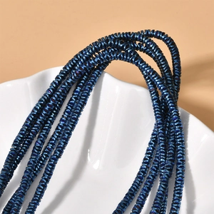 Macro detail of dark blue metallic wave disc spacer beads for DIY jewelry making