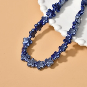 Detailed view of glossy dark blue ceramic flower beads for DIY jewelry making