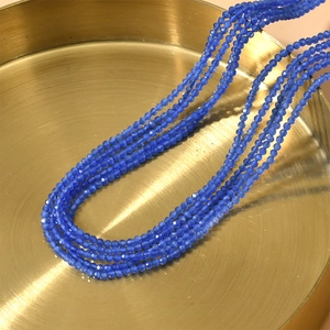 Detalle macro de collares de varias capas con cuentas de ojo de gato azul de 2mm en bandeja