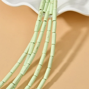 Macro detail of 4x13mm light green turquoise tube beads with natural brown marble texture