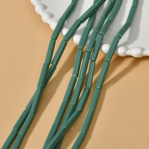 Gros plan de perles cylindriques vert sauge pour la création de bijoux DIY