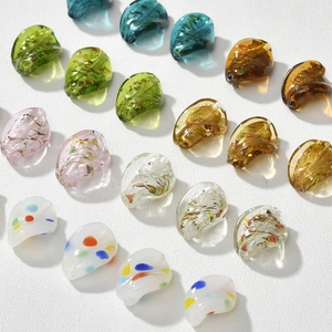 Dettaglio di perline in vetro a foglia di salice con foglia d'oro e pois per gioielli