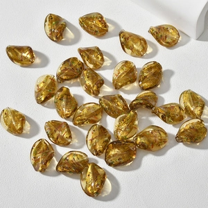 Vista macro di perline di vetro ritorte color ambra oro con foglia d'oro per gioielli DIY