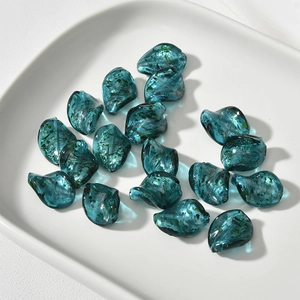 Dettaglio di perline in vetro a foglia di salice blu scuro con sabbia dorata per gioielli