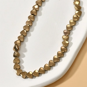 Close-up of 6mm faceted heart hematite beads for DIY jewelry making in bronze gold