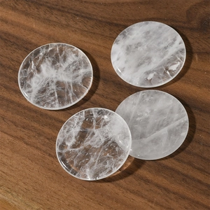Close-up of four natural white quartz discs with ice crack textures on wood background