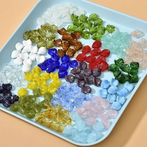 Colorful twisted leaf glass beads for DIY jewelry making displayed in a blue organizer tray