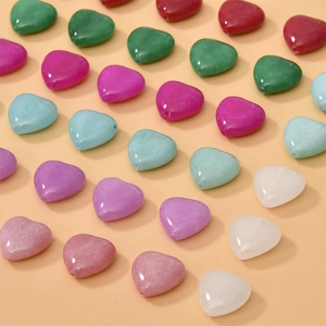 Close-up of colorful heart-shaped natural stone beads with holes for DIY jewelry making