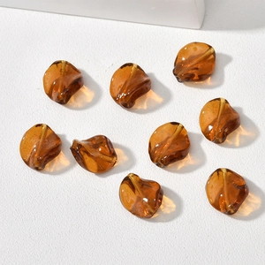 Detailed view of amber twisted leaf glass beads with central hole for DIY jewelry making