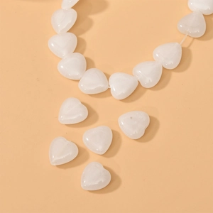 Detailed view of polished white heart-shaped natural stone beads for DIY jewelry making