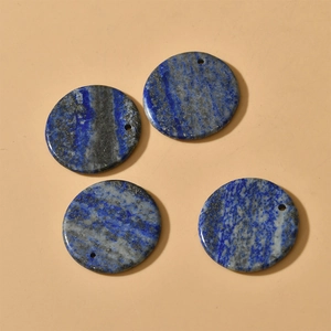 Flat lay of four round 30mm blue lapis lazuli stone beads with holes for DIY jewelry