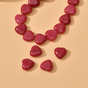 Macro shot of polished red heart-shaped natural stone beads for DIY jewelry making