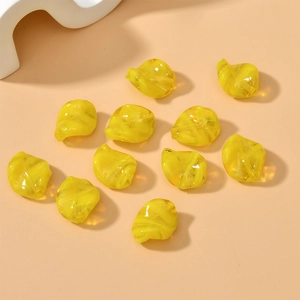 Macro shot of translucent yellow twisted glass beads with glossy texture for DIY jewelry