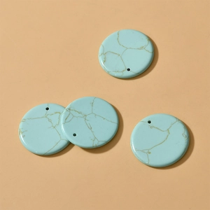 Detail of 30mm round blue turquoise stone pendants with golden veins and pre-drilled holes
